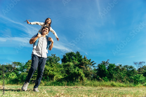 Daughter sits on his father's neck.The family enjoyed a holiday Holiday over beautiful nature.Concept People and family.