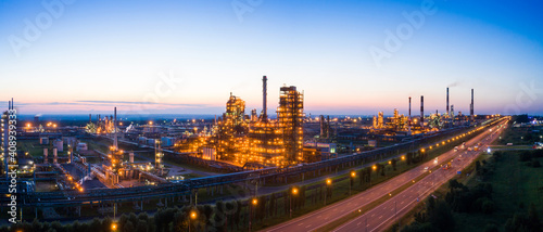 Oil refinery plant industry, Refinery factory. oil storage tank, rectification column and pipeline against the backdrop of sunset in summer, Russia.