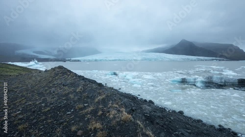 Time lapse of iceflows in a glacier lake in Iceland. A glacier can be seen in the distance photo