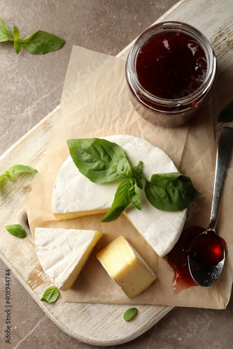 Concept of tasty eating with camembert and jam on cutting board