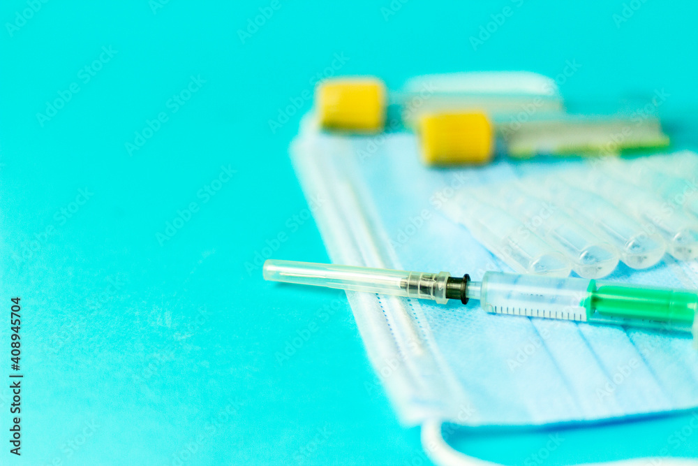 Medical vials for injection, syringe for injection, mask gloves on a blue background. Admission vaccination, flu shot. Medical vials for injection, syringe for injection, mask gloves on a blue background. Admission vaccination, flu shot.
