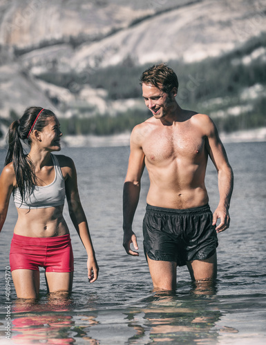 Canvas Print Swimming couple of swimmers having fun in cold water lake for winter polar plunge challenge outdoors