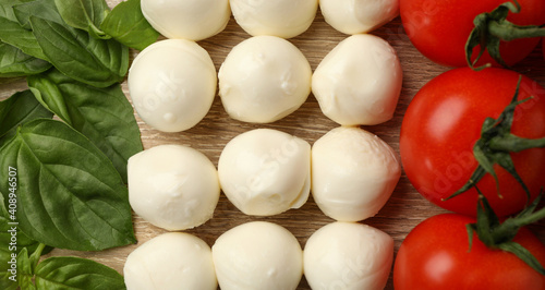 Flat lay with mozzarella, tomato and basil on wooden background, close up