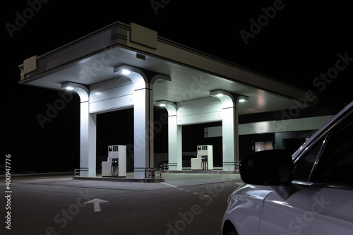Modern car driving to gas station at night, closeup © New Africa