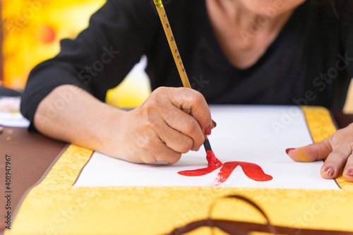 Hand of Vietnamese scholar writes calligraphy at lunar new year. Calligraphy festival is a popular tradition during Tet holiday. photo