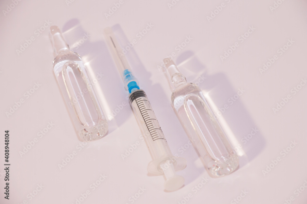 two ampoules and a syringe on a white background, coronavirus vaccine. two ampoules and a syringe on a white background, coronavirus vaccine.