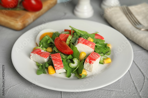 Delicious crab stick salad served on grey table