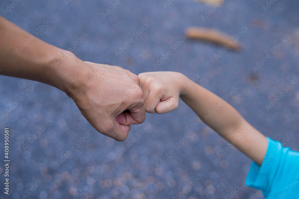 Little child and father bumping fists, man and child giving knuckle bump. Little child and father bumping fists, man and child giving knuckle bump.