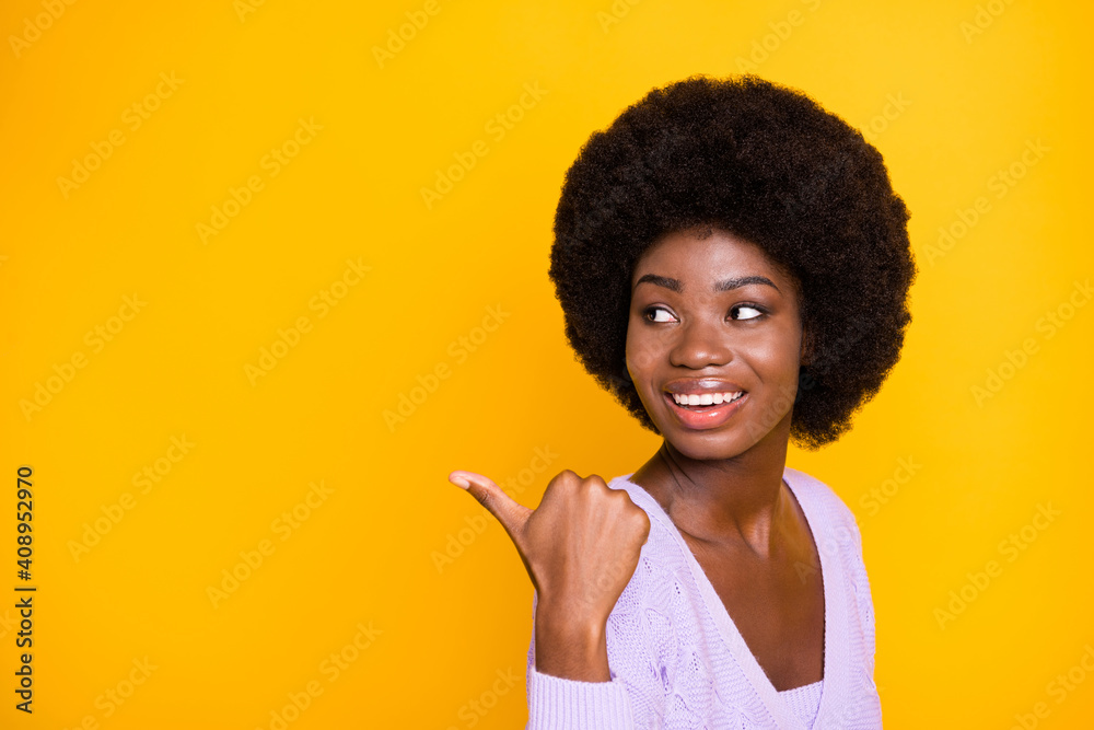 Profile portrait of pretty dark skin girl look direct thumb empty space promotion isolated on yellow color background Profile portrait of pretty dark skin girl look direct thumb empty space promotion isolated on yellow color background