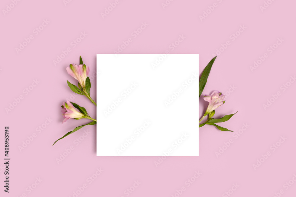 Composition with flowers and blank paper on a purple background. Greeting card mockup. Composition with flowers and blank paper on a purple background. Greeting card mockup.