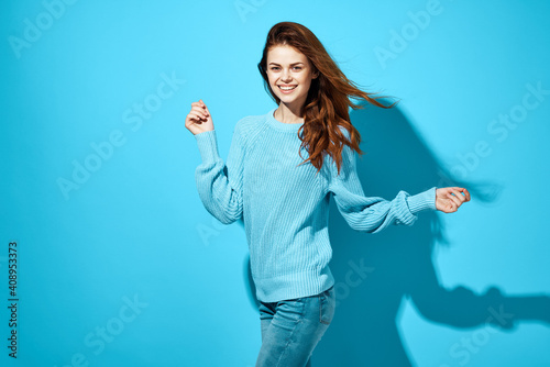 woman in blue sweater and jeans posing casual wear studio isolated background