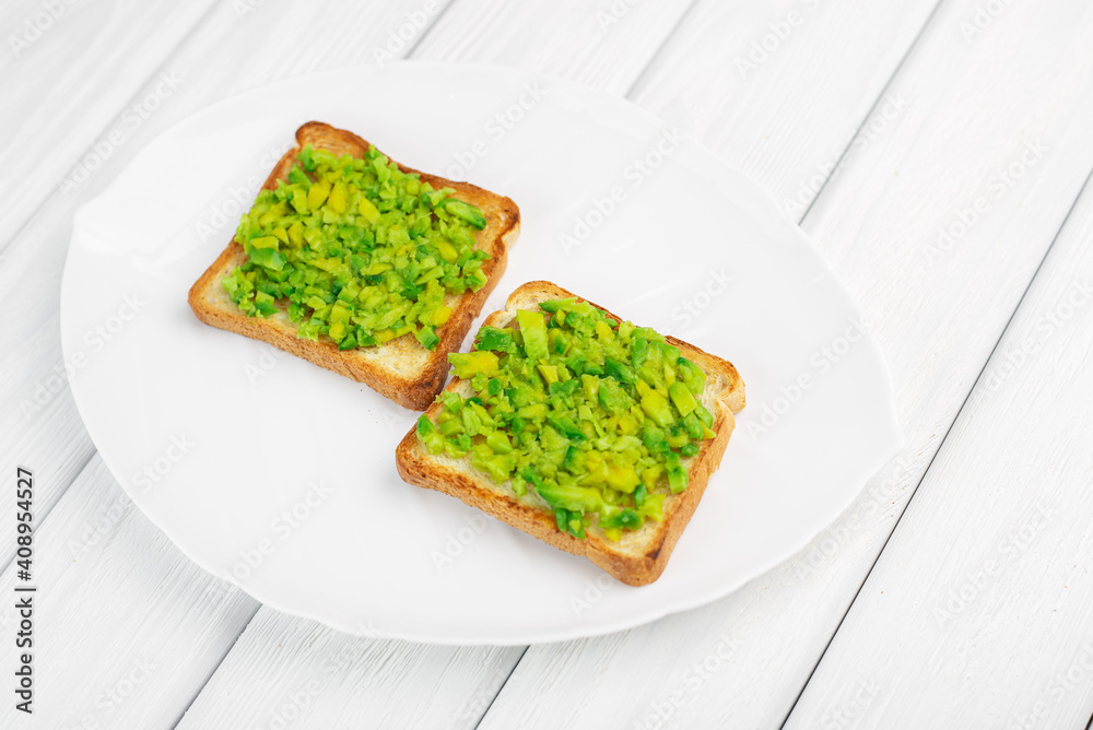 Toasts with avocado on white wood background Toasts with avocado on white wood background