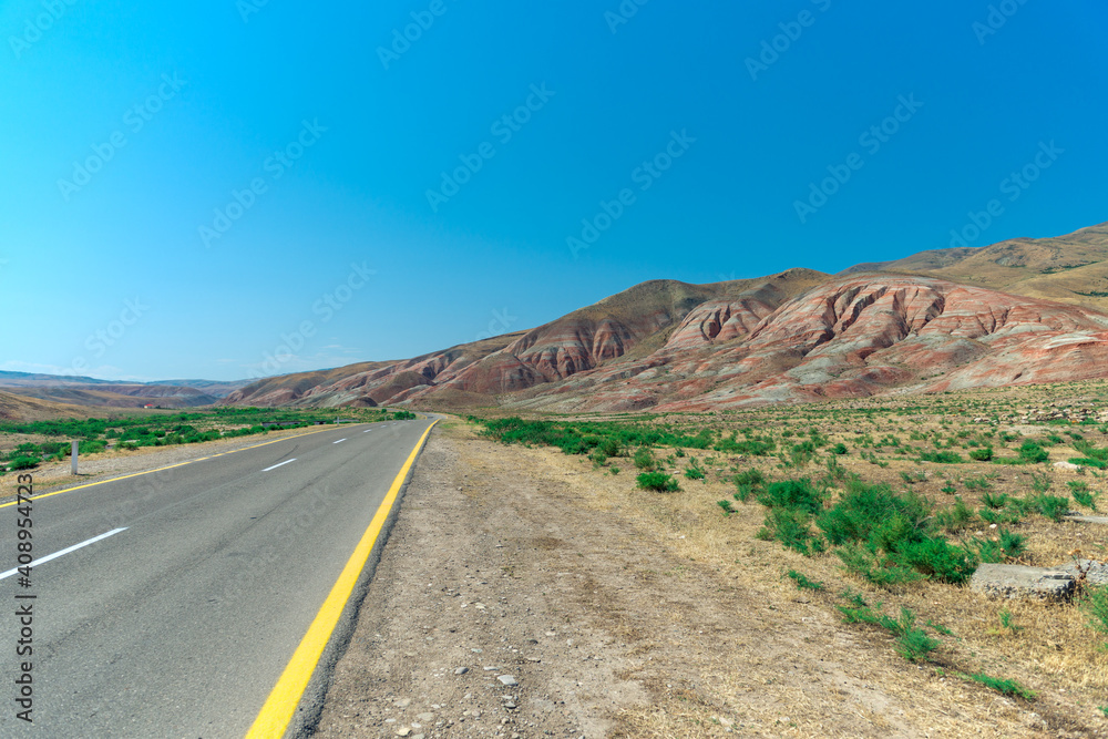 Cross-bedding in Candy Cane Mountains in Azerbaijan and road. Colorful stripes of the hills. Shale striped mountains