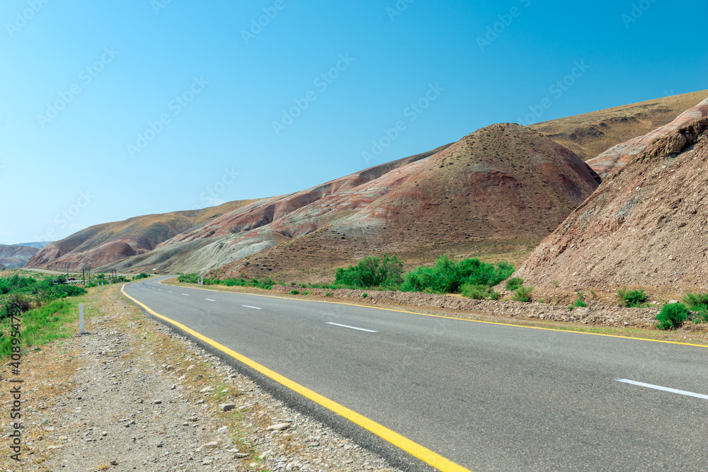 Cross-bedding in Candy Cane Mountains in Azerbaijan and road. Colorful stripes of the hills. Shale striped mountains