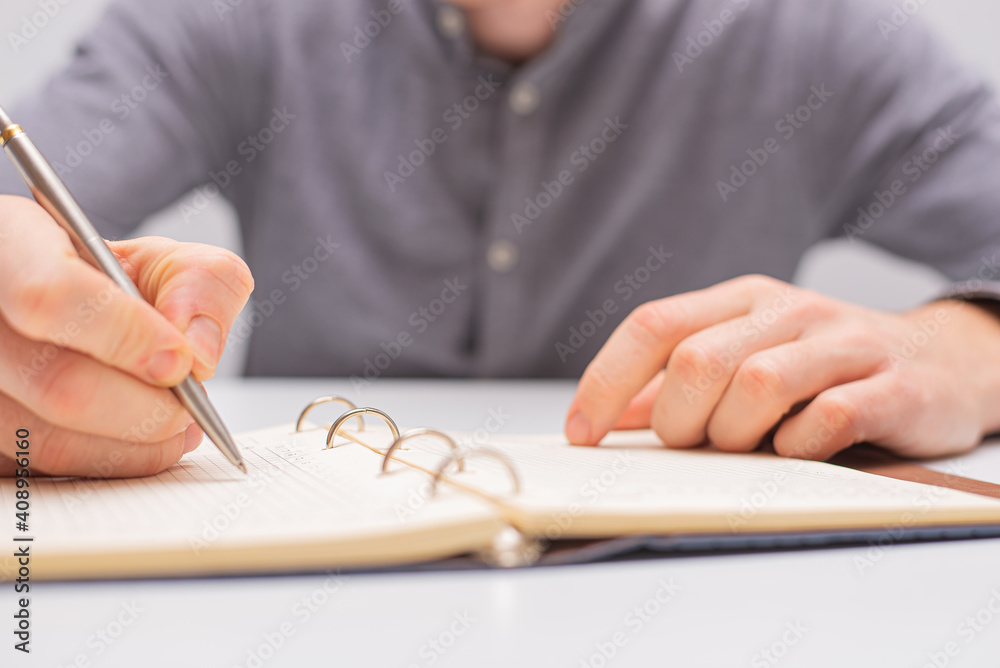 Naklejka premium person writing on a notebook