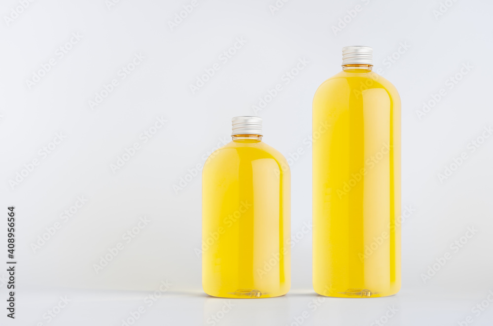 Set of two plastic tall and low bottles with orange drink, cooking oil or cosmetic produce, silver cap mockup on white background, template, copy space. Set of two plastic tall and low bottles with orange drink, cooking oil or cosmetic produce, silver cap mockup on white background, template, copy space.