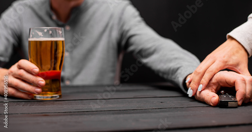 Drunk man with car key and alcoholic beverage in bar, closeup. Don't drink and drive concept