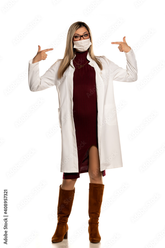 Young beautifuls female doctor with eyeglasses pointing on her face medical mask Young beautifuls female doctor with eyeglasses pointing on her face medical mask