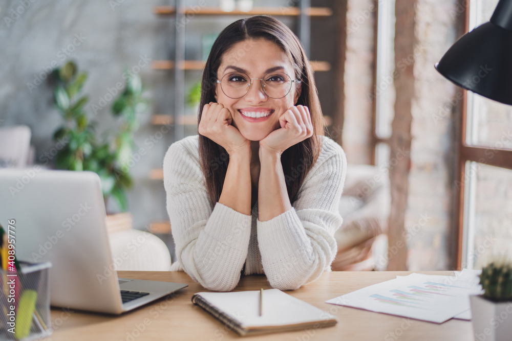 Photo of cheerful lady sit desk laptop notebook hands cheeks wear glasses white sweater in living room home indoors Photo of cheerful lady sit desk laptop notebook hands cheeks wear glasses white sweater in living room home indoors