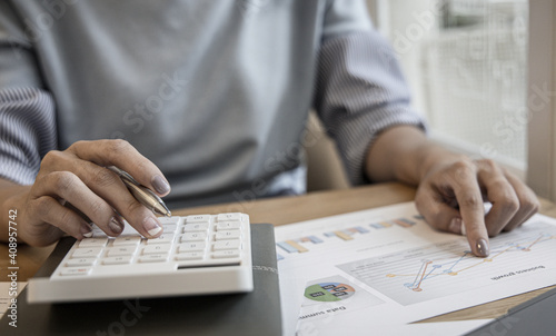Financial businesswoman calculating corporate income tax data And analyzing charts of financial stocks that are in good condition with growth and progress, Investment in finance.