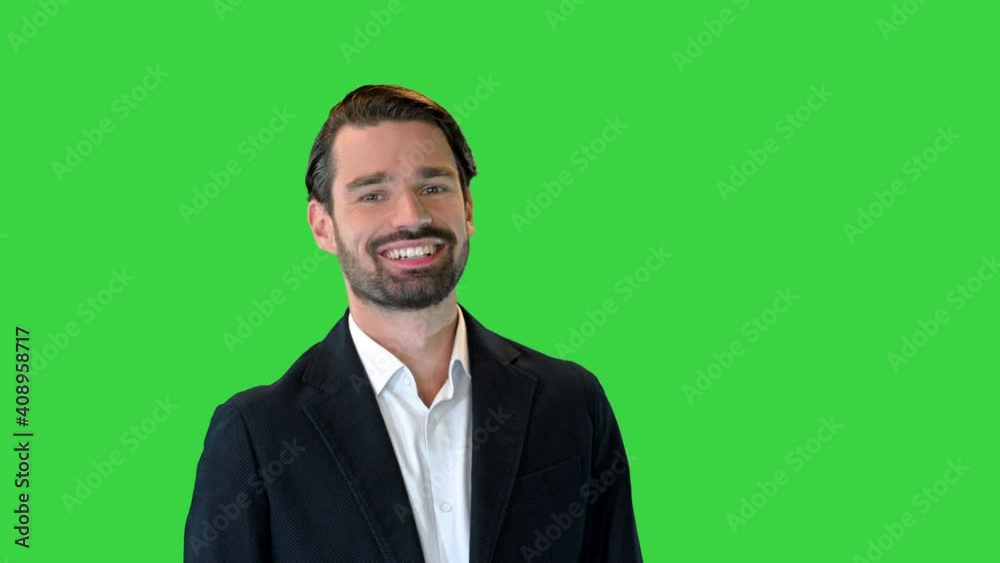 Handsome young man winking to you with smile while standing on a Green Screen, Chroma Key. Handsome young man winking to you with smile while standing on a Green Screen, Chroma Key.