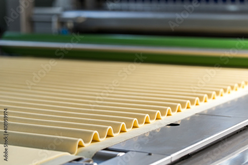 Dough on conveyor line preparing for biscuits making © Retan