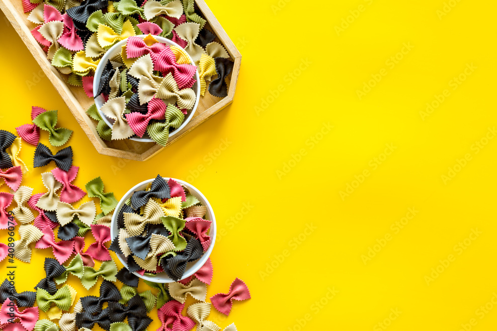 Top view of coloured farfalle pasta in bowls