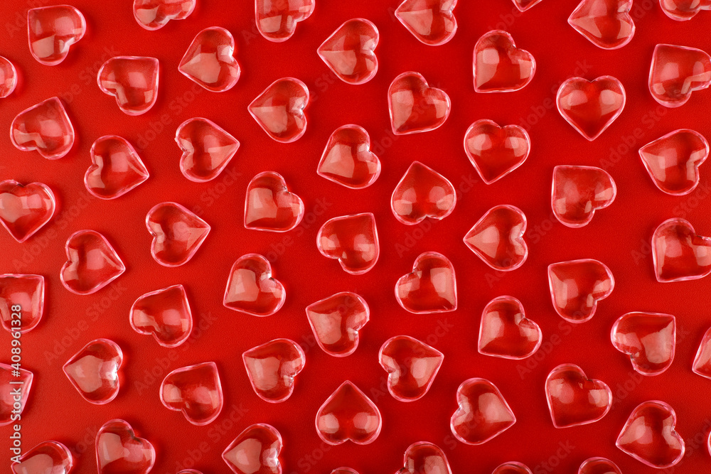 Red background with transparent glossy glass hearts. Concept of love and St. Valentine's day
