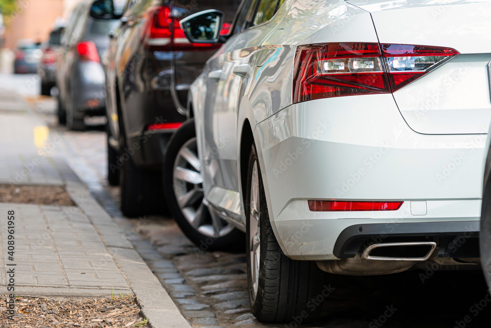 rows of cars parked along the roadside in crowded city rows of cars parked along the roadside in crowded city