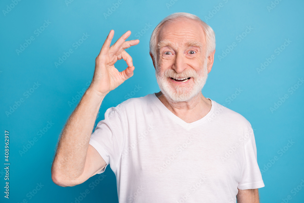 Photo portrait of elderly man showing ok-sign isolated on pastel blue colored background