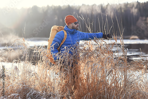 winter landscape forest backpack man / traveler in modern winter clothes in the forest, traveling in the mountains  europe, switzerland winter photo