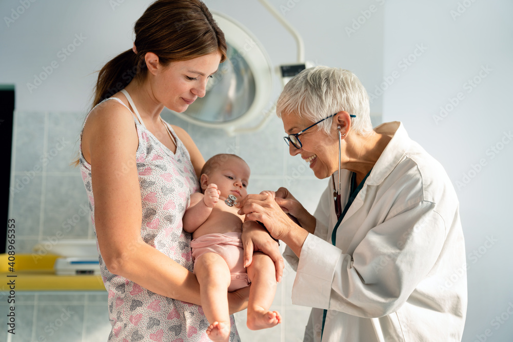 Mother holding baby for pediatrician doctor to examine Mother holding baby for pediatrician doctor to examine