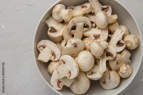 Fresh whole and chopped mushrooms in a round porcelain bowl