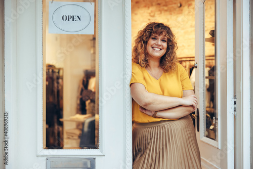 Successful fashion store owner standing at entrance door