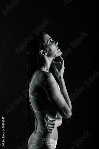 Young sexy woman posing in water studio.