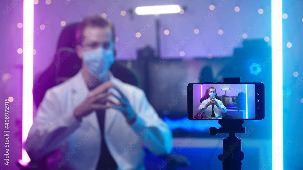 Doctor with face mask recording with smartphone in futuristic office Doctor with face mask recording with smartphone in futuristic office