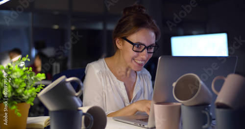 Super energetic businesswoman working late in office drinking too much caffeine photo