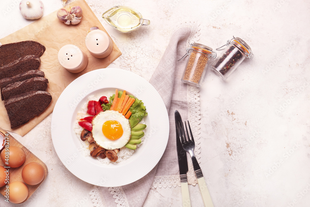 Plate with tasty egg, vegetables and rice on light background Plate with tasty egg, vegetables and rice on light background
