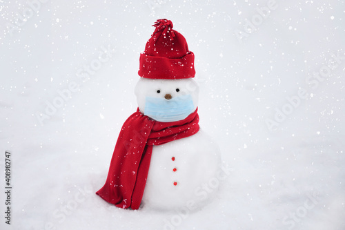 Snowman wearing a face mask, winter hat. scarf on a white background © Mariia