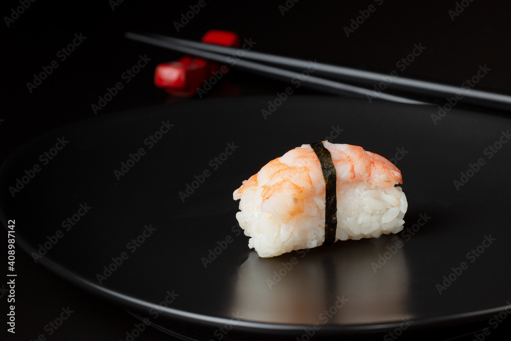 sushi with chopsticks, sushi on a plate, sushi and chopsticks