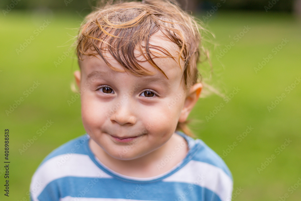 Close up portrait of a little smiling boy in the parks. Adorable child of two years old with sweaty hairs in hot summer weather. Close up portrait of a little smiling boy in the parks. Adorable child of two years old with sweaty hairs in hot summer weather.
