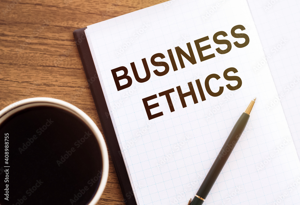 BUSINESS ETHICS - text on notepad on wooden desk. BUSINESS ETHICS - text on notepad on wooden desk.