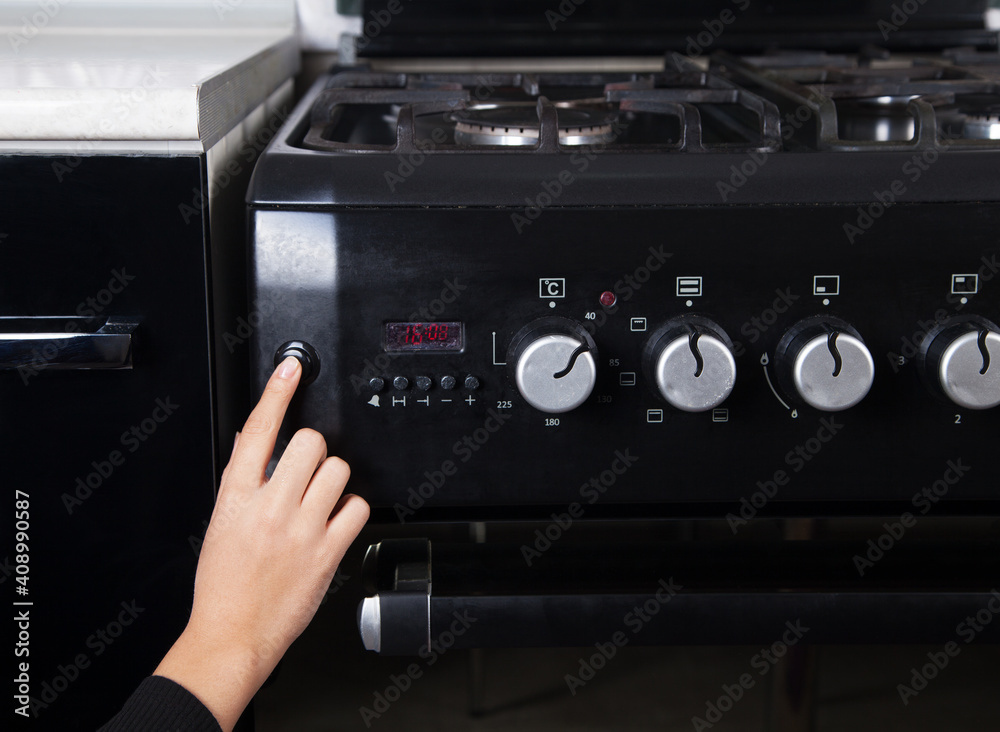 Obraz premium Gas stove and woman in the kitchen.