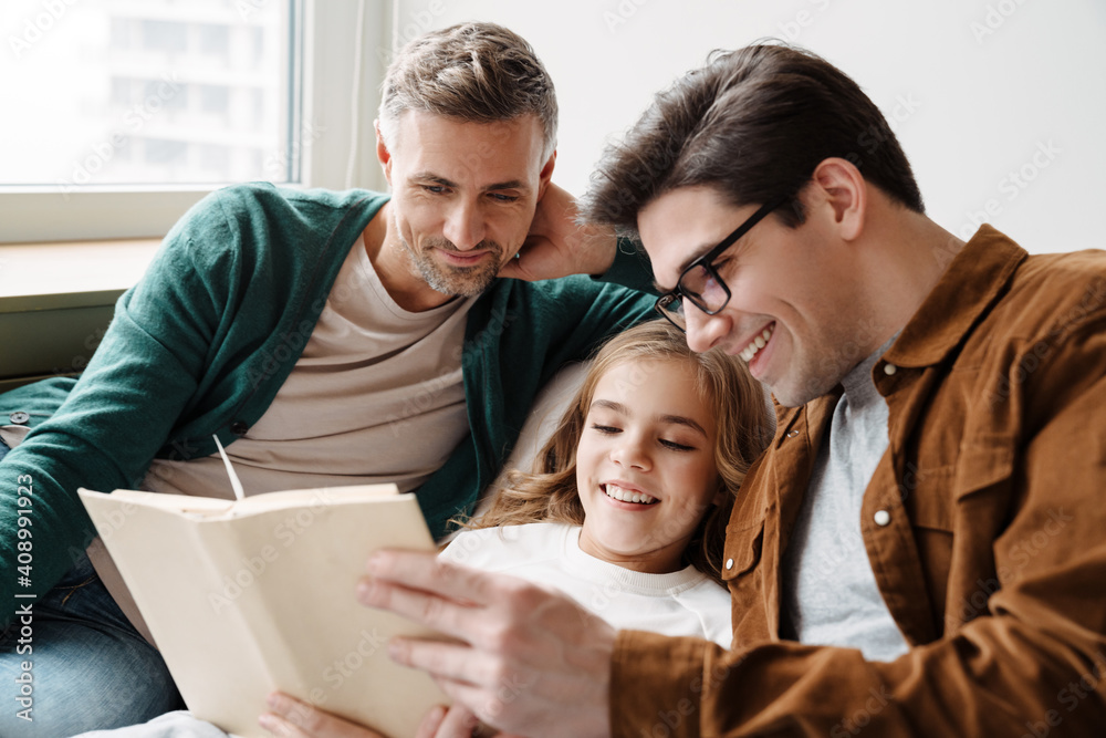 © Drobot Dean - Happy gay parents reading book together © Drobot Dean - Happy gay parents reading book together
