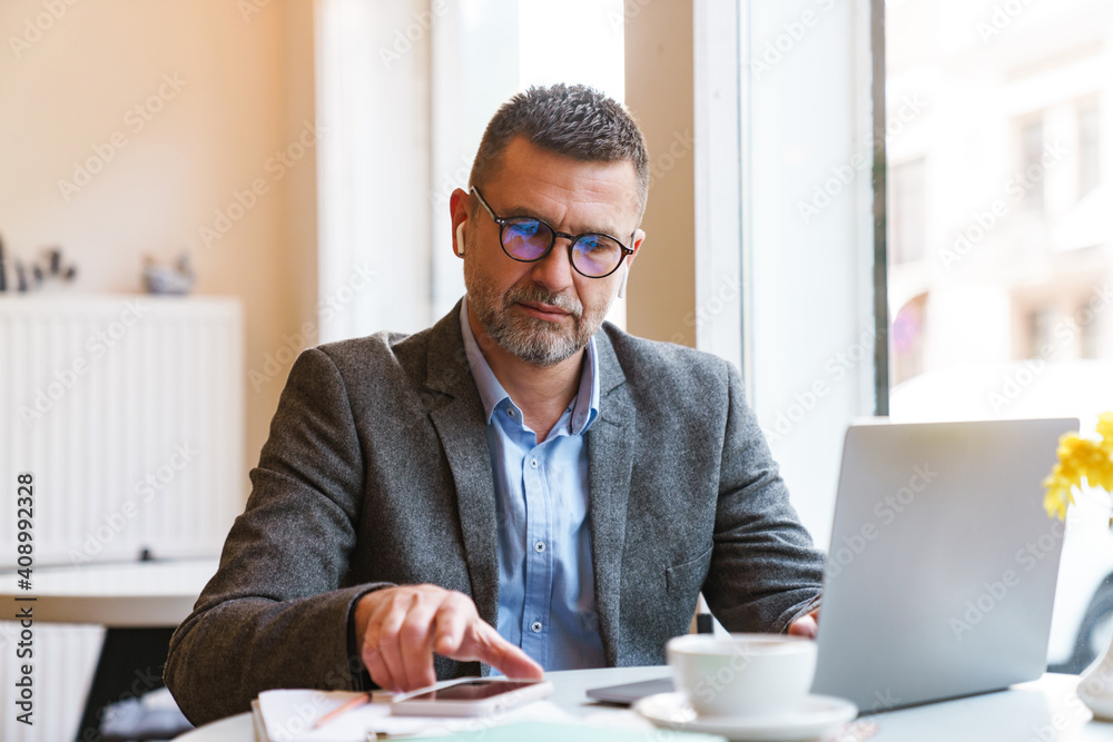 Handsome confident businessman working on laptop Handsome confident businessman working on laptop