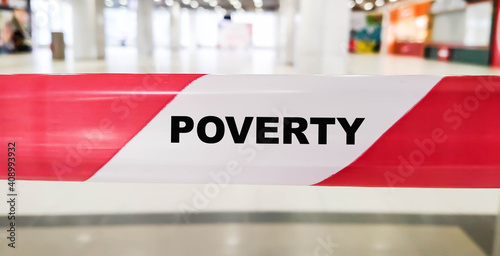 Poverty inscription on a red ribbon. Financial text indoors