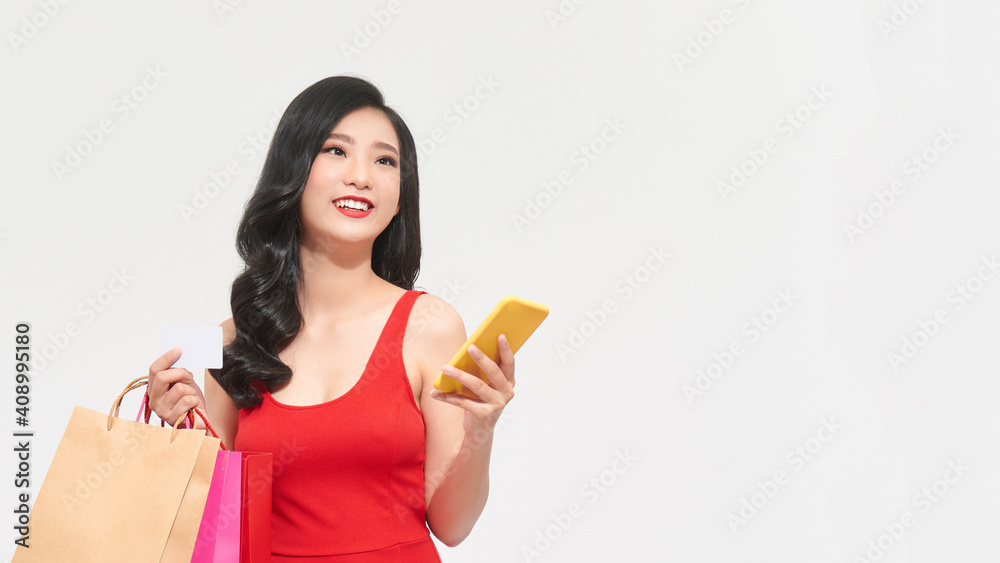 happy asian lady holding some shopping bags using her phone and credit. woman shopping concept happy asian lady holding some shopping bags using her phone and credit. woman shopping concept