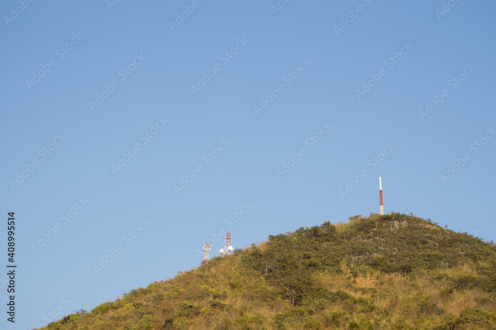 The antenna is located on a high mountain for the most efficient transmission. Blue sky background