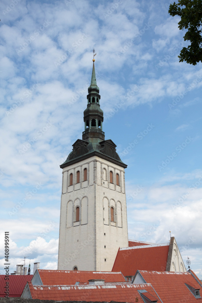 View of the famous Saint Nicholas church (Niguliste) with red roofs and castle in medieval walled old town of Tallinn Estonia in the Baltics region of Northern Europe