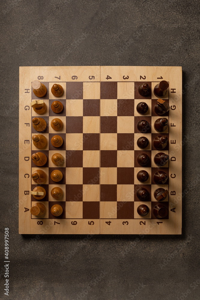 Chess pieces on a chessboard on a dark background Chess pieces on a chessboard on a dark background